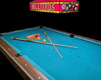 Billiard table with cues, balls, rack and classic stained glass light fixture
