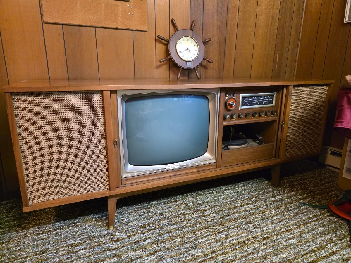 vintage mid-century modern Curtis Mathest, integrated cathode-ray tube (CRT) television, a radio receiver, and a record player turntable enclosed in a long wooden cabinet with fabric speaker grills on either sside. Absolutely Beautiful!! Did not plug in to test.