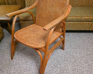 Vermont Tubbs, vintage wooden armchair featuring a curved wood frame with woven cane seating and an oval backrest, similar in style to mid-century Scandinavian