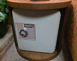 mid-century modern barrel-style end table featuring a roll-away door that conceals a gray Sentry combination safe inside.