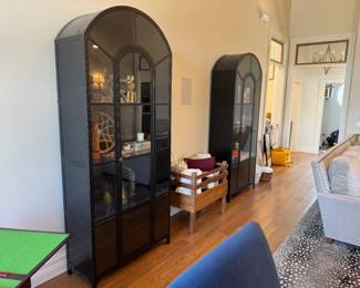 Two 7'6" x 39" tall black metal and glass arched apothecary cabinets, purchased from Checkered Moon in Champaign. Cabinets are 39" x 16" 7'6