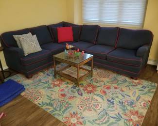 Navy sectional sofa with red piping - classic! Floral rug