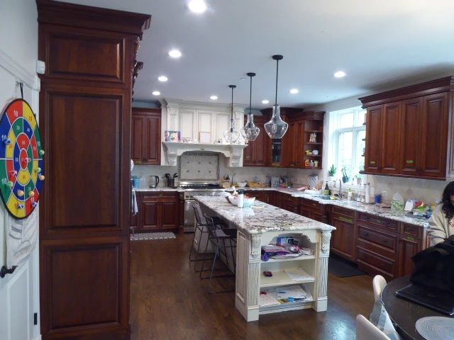 Full custom kitchen removed as one lot; buyer must uninstall and pick up Uppers include: 60x108, 31x108 pantry runs, 47x59, 72x54, 25x47, 27x54 corner, 36x47, 28x47, 47x25 over-fridge Base cabinets include: 49-1/2 sink base, 30 base, 41 prep, 24 dishwasher panel, 32 3-drawer, 13 door, 12 filler Island approx 38" X 110" with granite top, four fluted turned legs (4 in square), open shelving on end Painted mantel-style range hood surround with carved acanthus corbels and dentil molding Two glass-front corner display cabinets (27x54 corner) with seeded/textured glass Cherry raised-panel doors, dentil crown molding, fluted pilasters, ornate iron pulls Granite (Bianca Antico style) countertops included; undermount stainless double-bowl sink included $9,250.00.