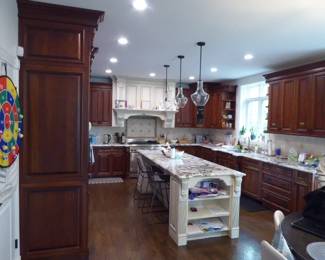 Full custom kitchen removed as one lot; buyer must uninstall and pick up Uppers include: 60x108, 31x108 pantry runs, 47x59, 72x54, 25x47, 27x54 corner, 36x47, 28x47, 47x25 over-fridge Base cabinets include: 49-1/2 sink base, 30 base, 41 prep, 24 dishwasher panel, 32 3-drawer, 13 door, 12 filler Island approx 38" X 110" with granite top, four fluted turned legs (4 in square), open shelving on end Painted mantel-style range hood surround with carved acanthus corbels and dentil molding Two glass-front corner display cabinets (27x54 corner) with seeded/textured glass Cherry raised-panel doors, dentil crown molding, fluted pilasters, ornate iron pulls Granite (Bianca Antico style) countertops included; undermount stainless double-bowl sink included $9,250.00.