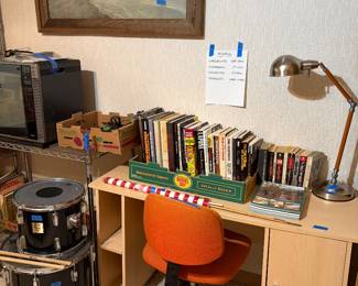 2 Yamaha drums, books on organized crime, cool vintage desk lamp, blonde wood desk
