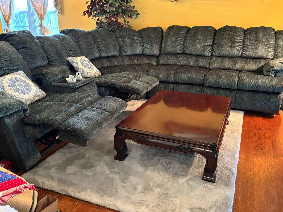 Sectional sofa with recliners and console    Large solid dark wood Asian-style low coffee table with glossy top and carved sides 