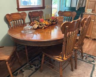 classic solid oak dining table set with an oval top and matching spindle-back chairs