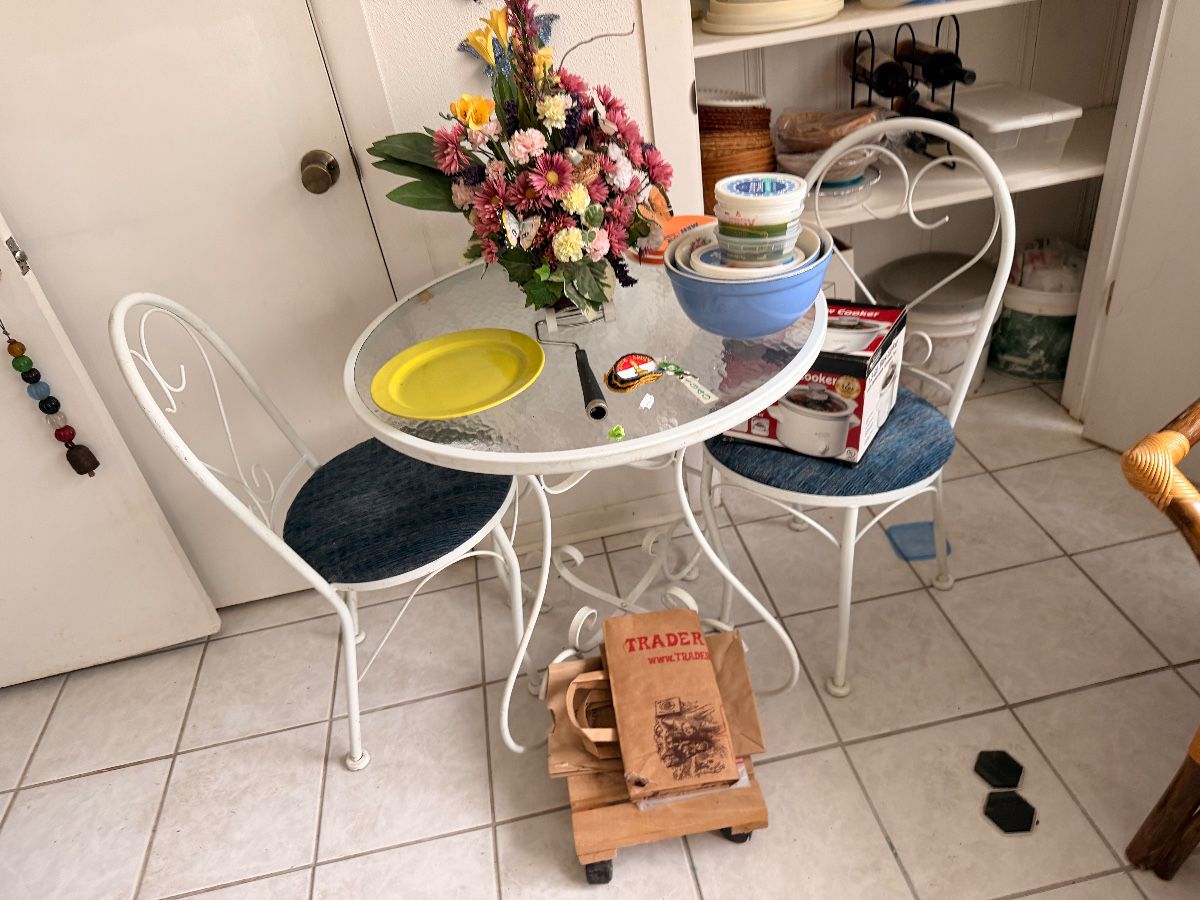 White wrought iron French cafe table with two chairs