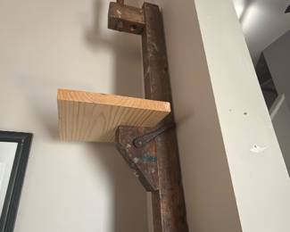 rustic wall shelf made by mounting a vintage wooden screw clamp