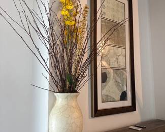 white ceramic vase and framed art
