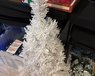 small, white tabletop artificial Christmas tree