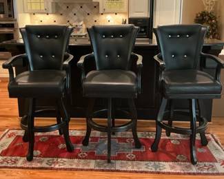 Three Black Upholstered Swivel Bar Stools With Rug