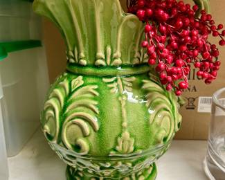 Ornate green glazed ceramic pitcher with a fluted rim