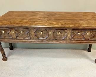 Vintage Jacobean-style oak coffee table with carved panel drawers, brass hardware and turned legs
