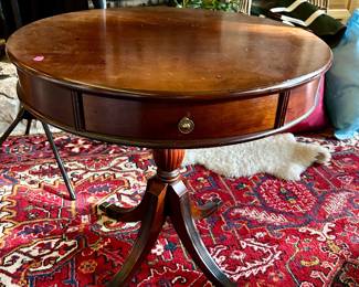 Oval wood accent table with a single drawer, pedestal base, and brass-tone feet