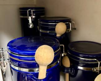 Set of four cobalt blue ceramic canisters with clamp lids and wooden spoons
