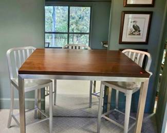 Room & Board counter-height table with a warm wood top and sleek stainless steel base, paired with four silver counter stools