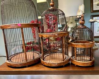 Set of three decorative birdcages in graduated sizes, with wood bases and dark metal bars
