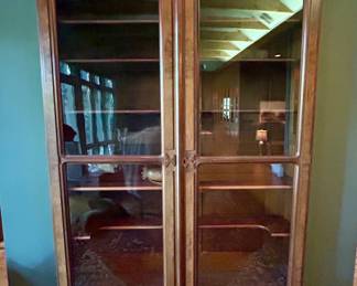 Carved wood display cabinet/bookcase with double glass doors, interior shelving and two lower drawers
