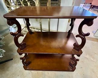 Three-tier wooden accent table with carved scroll supports