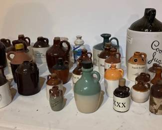 Collection of vintage and antique ceramic stoneware whiskey and moonshine jugs