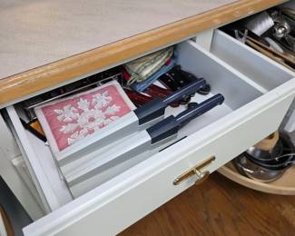Kitchen drawer with knives, playing cards and utensils