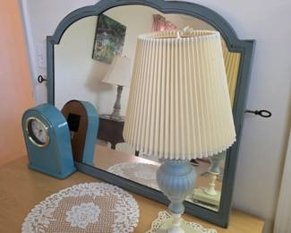 Vintage blue dresser mirror with blue clock, lamp and lace doilies