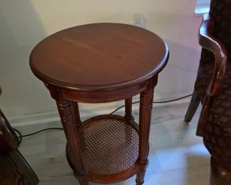Round mahogany accent table with caned lower shelf