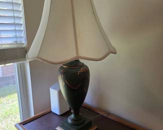 Green urn-shaped table lamp with gold accents, cream shade