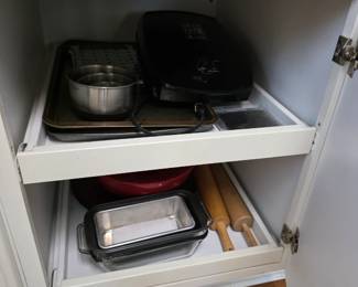 Kitchen cabinet with grill, baking sheets, loaf pan and rolling pins