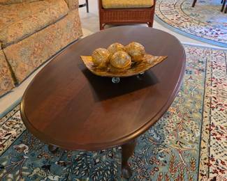 Oval wood coffee table with decor bowl, Persian-style area rug