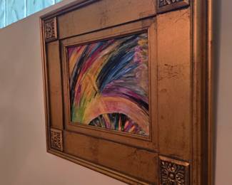 Framed abstract artwork in ornate gold wood frame