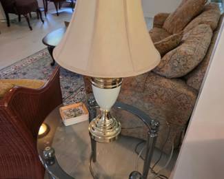 Round glass-top end table with cream and brass table lamp