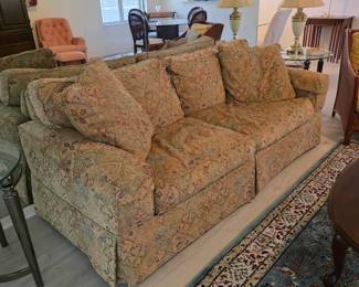 Floral tapestry-style sofa with throw pillows, skirted base
