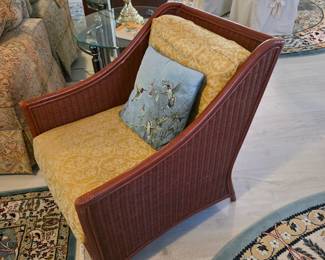Wicker armchair with gold damask cushions and accent pillow