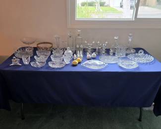 Crystal and decorative glassware assortment with decanters, stemware, bowls, plates and serving pieces.