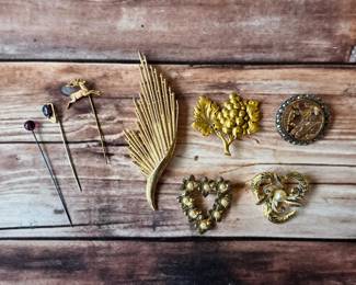 Vintage brooches and stickpins with floral, leaf and decorative designs.