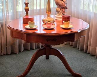 Round wood pedestal table with curved legs, decorative table lamp and colorful Danish cups and saucers.