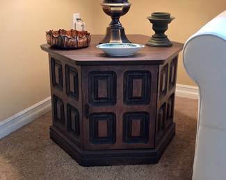 Vintage polygonal wood end table with paneled sides, displayed with a traditional table lamp.