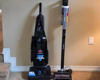 Upright carpet cleaner and stick vacuum cleaner among the household cleaning equipment.