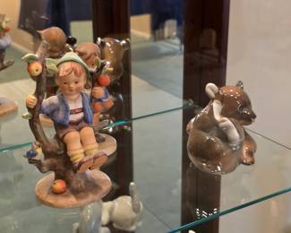 Genuine Hummel child figurine with a fruit-laden tree, displayed beside a small animal figure.