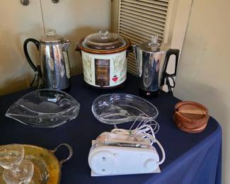 Vintage kitchen appliances and serving pieces, including a slow cooker, electric coffee pot and hand mixer.