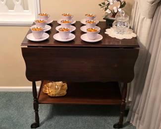 Vintage drop-leaf serving table with lower shelf, displayed with Danish gold-interior cups and saucers.