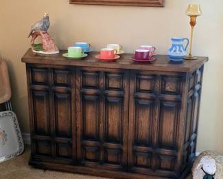 Vintage wood accent cabinet with geometric paneled doors and a dark contrasting finish.