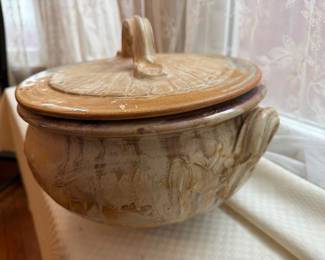 handcrafted stoneware casserole dish featuring an earth-toned glaze and a textured, radial-grooved lid