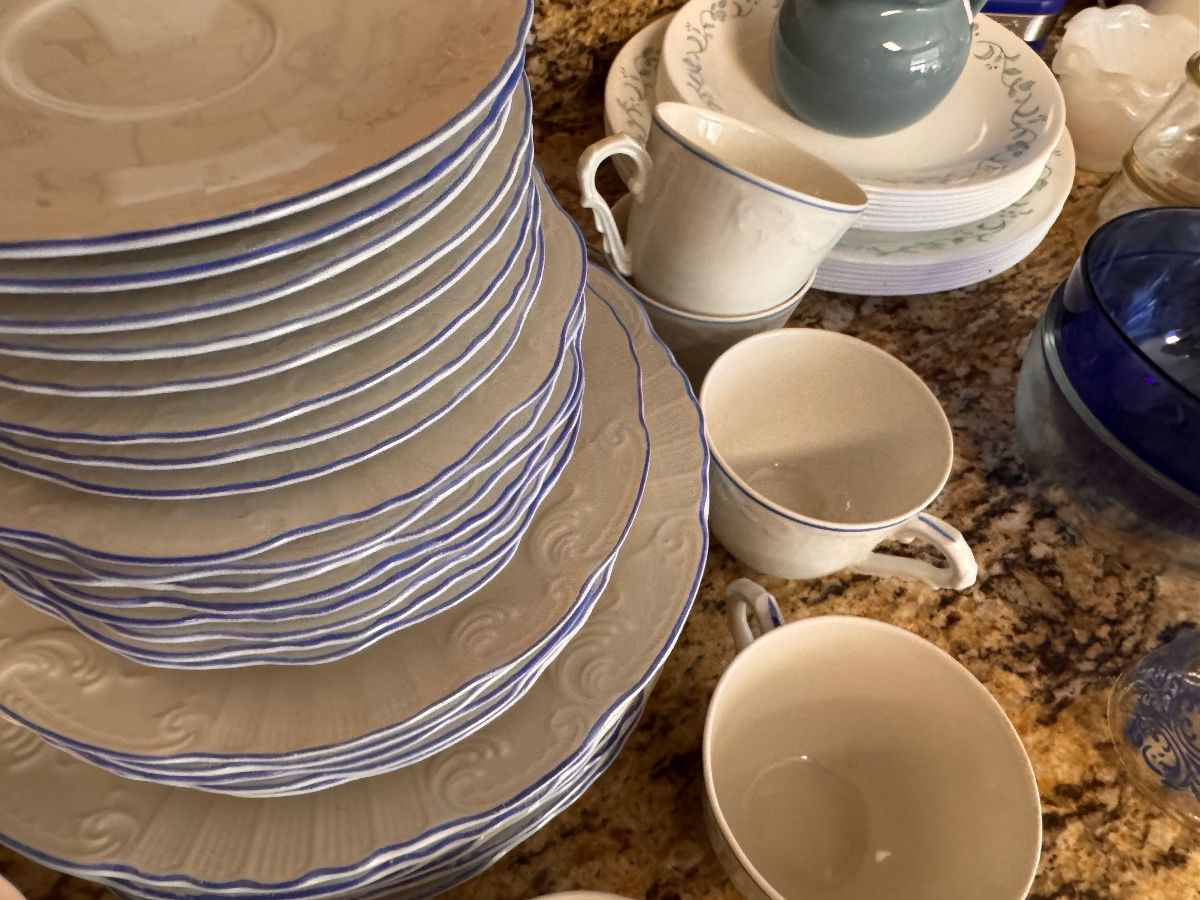 Stack of white dinnerware plates with cups and saucers