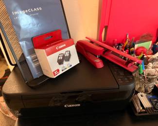 Printer with extra ink cartridges and desk supplies