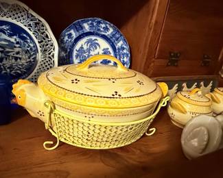 Stoneware Chicken Soup Tureen Collection – Vintage stoneware serving collection featuring a chicken-shaped soup tureen with matching lid and metal warming stand, along with coordinating covered soup bowls. Decorated with a hand-painted country chicken motif in warm yellow and brown tones. A charming set for serving soups, stews, or displaying in a farmhouse kitchen.