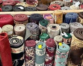 Assorted rolled area rugs in traditional, Persian-style and contemporary patterns