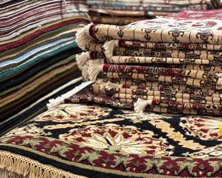 Assorted stacked traditional area rugs with Persian and Oriental-inspired designs